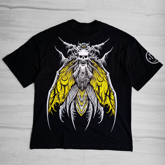 Black t-shirt with a graphic design of a skull with wings on a wooden surface
