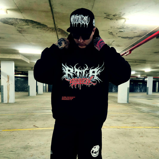 Person wearing a black hoodie with graphic design in an underground parking garage