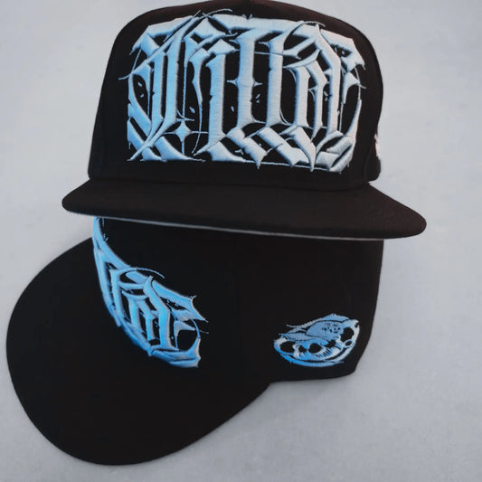 Black cap with blue and white designs on a light gray background