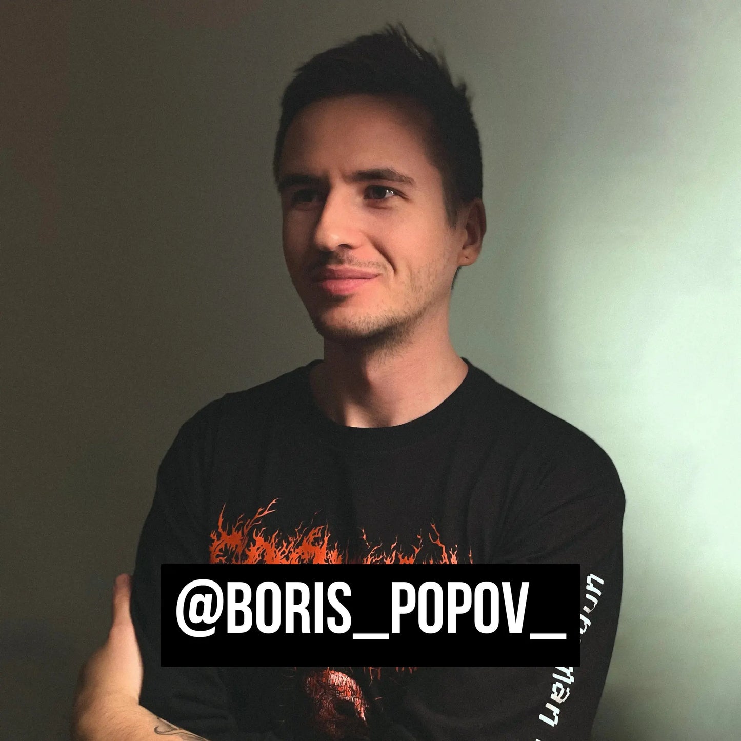 @boris_popov_ wearing a black t-shirt with a graphic design and text overlay on a plain background