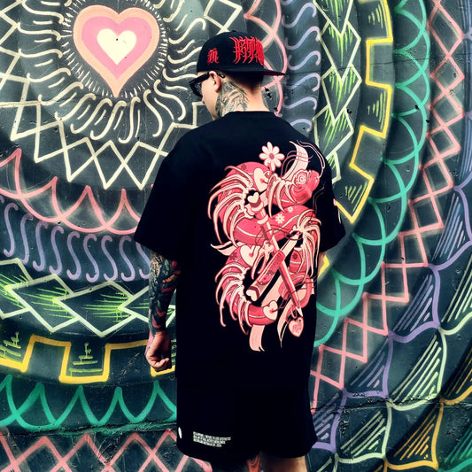 Person wearing a black t-shirt with a red dragon design, standing in front of a colorful wall.