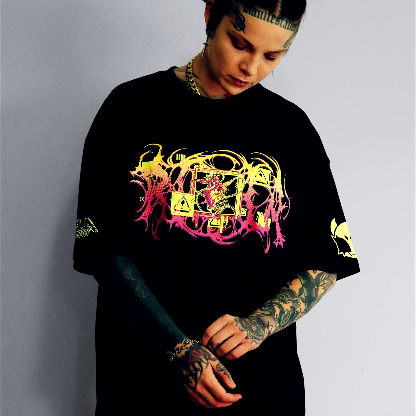 Person wearing a black t-shirt with colorful graphic design on a plain background