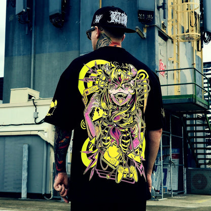 Person wearing a black t-shirt with a colorful graphic design, standing in an urban setting.