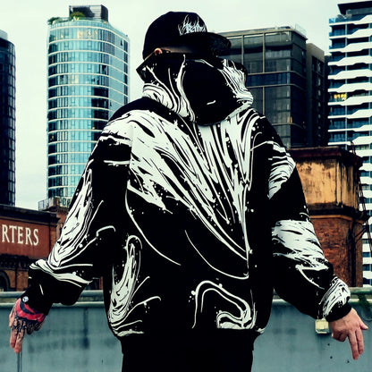 Person wearing a black and white jacket with a cityscape background