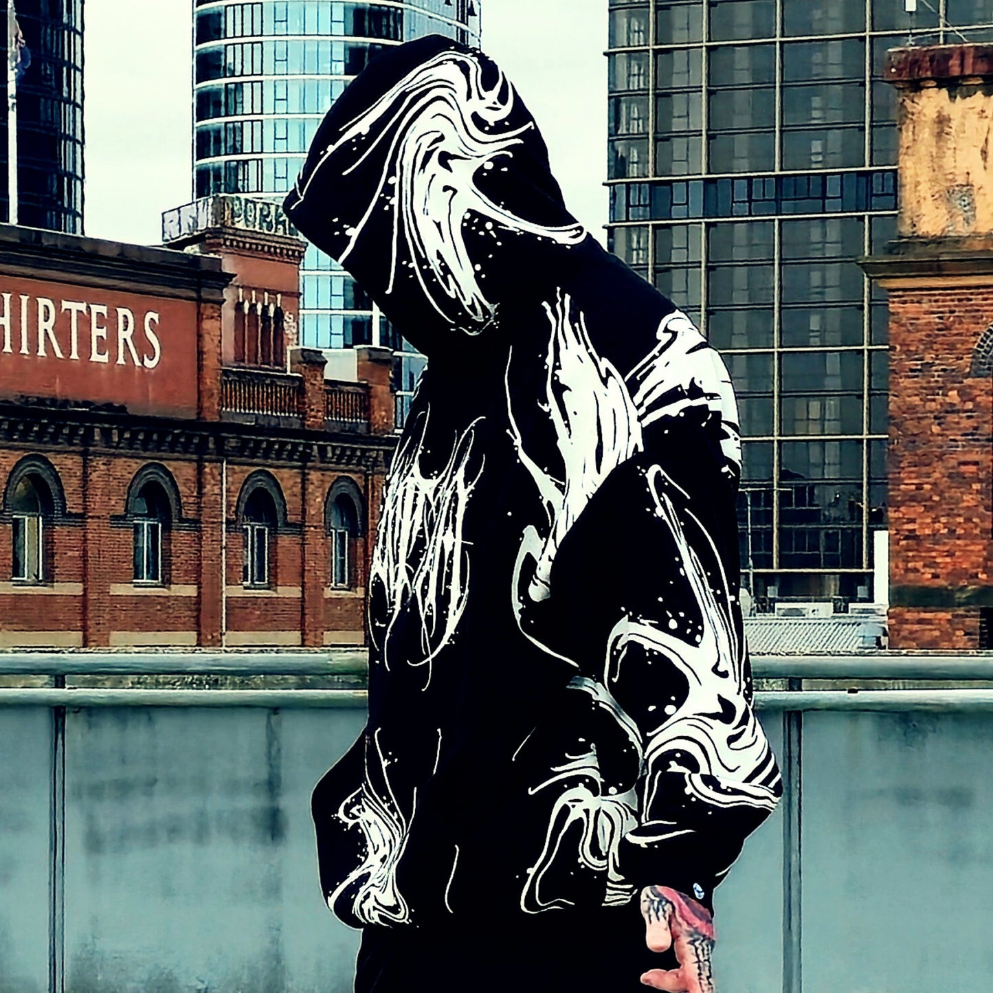 Person wearing a reflective hoodie with urban background