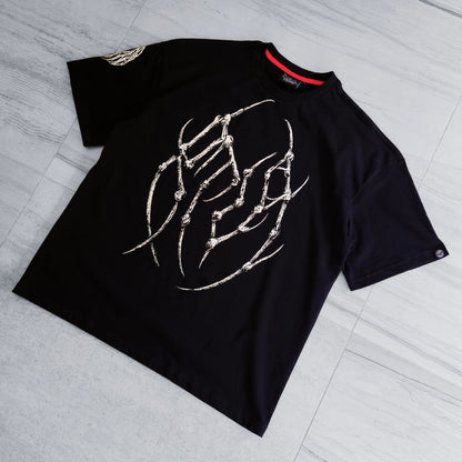 Black t-shirt with white graphic design on a gray floor
