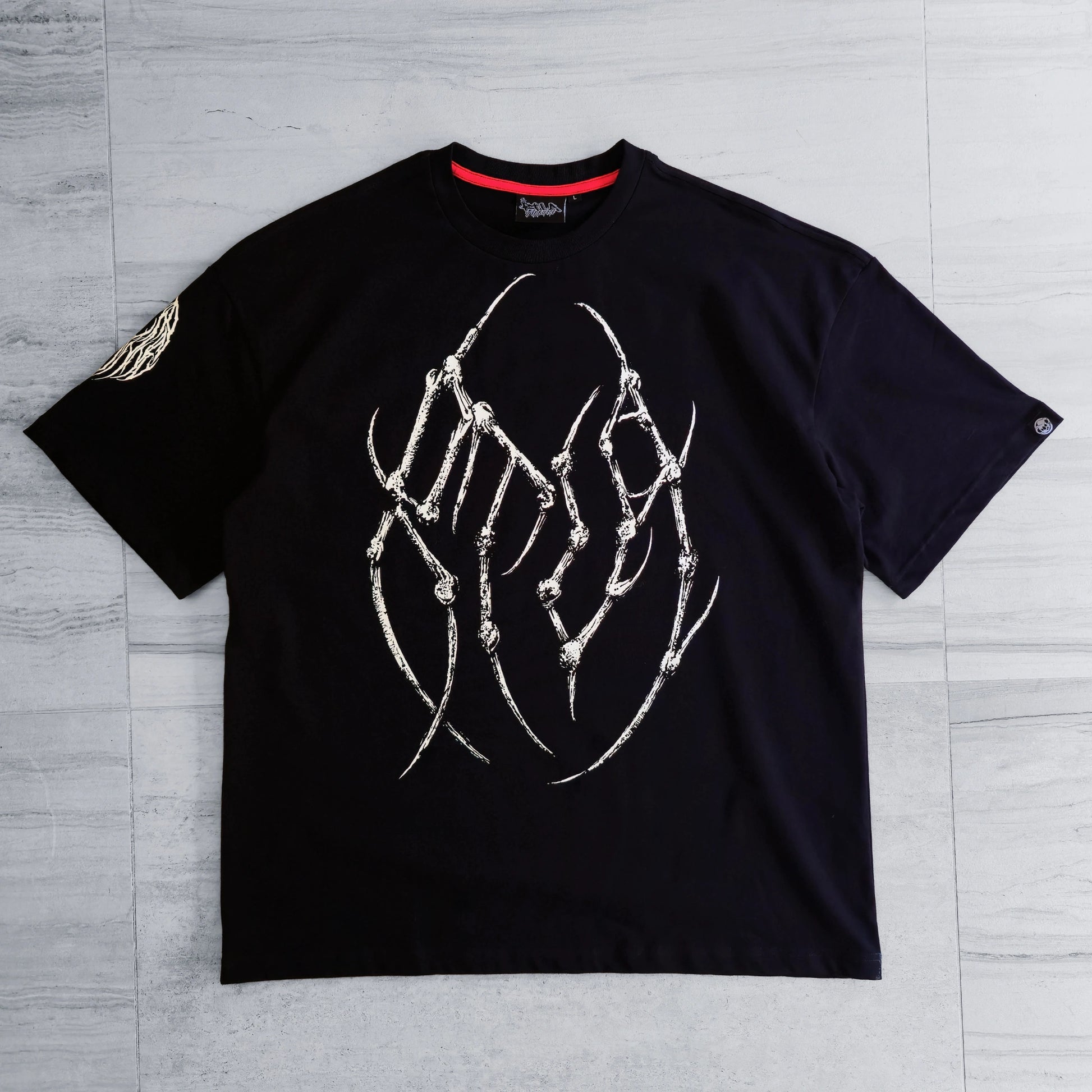 Black t-shirt with white graphic design on a gray wooden surface