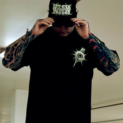 Person wearing a black hoodie with a logo and a black cap with white text.