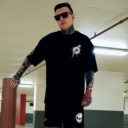 Man wearing a black t-shirt with a logo in an indoor setting