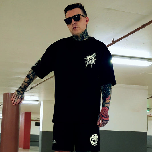 Man wearing a black t-shirt with a logo in an indoor setting
