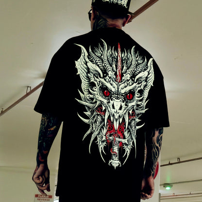 Person wearing a black t-shirt with a dragon design on the back, standing indoors.