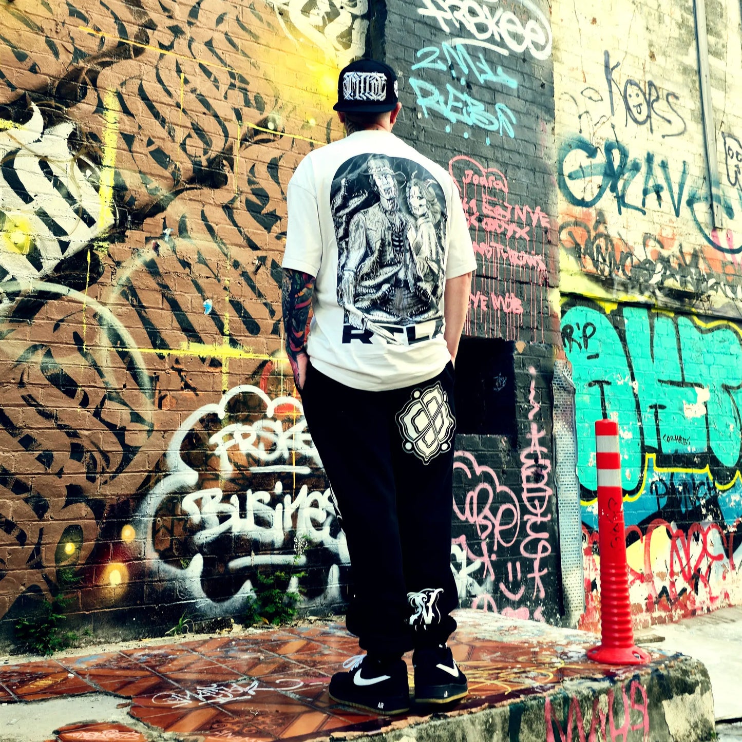 Person standing in front of a graffiti-covered wall