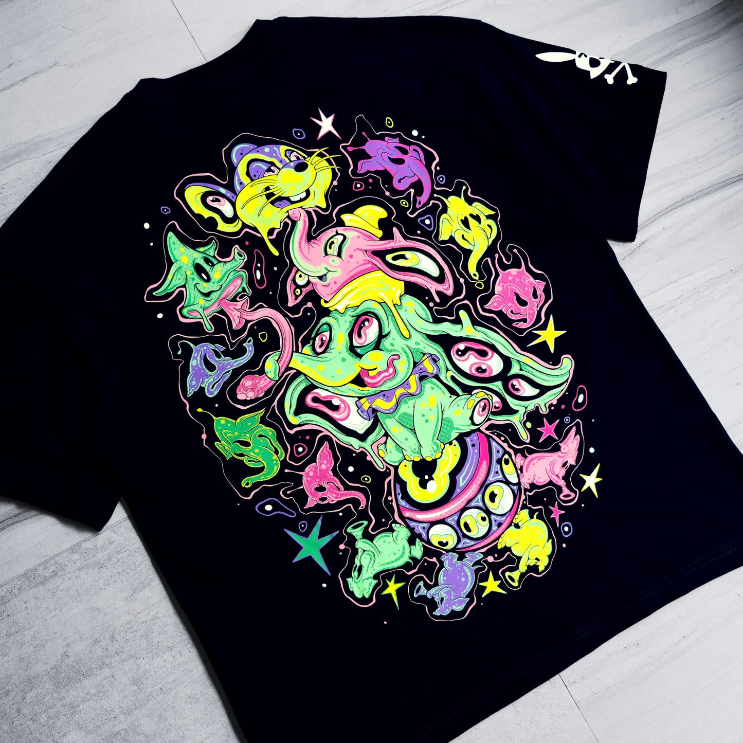 Black t-shirt with colorful abstract design on a light gray surface