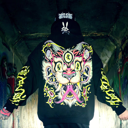 Person wearing a black hoodie with a colorful tiger design in an urban setting