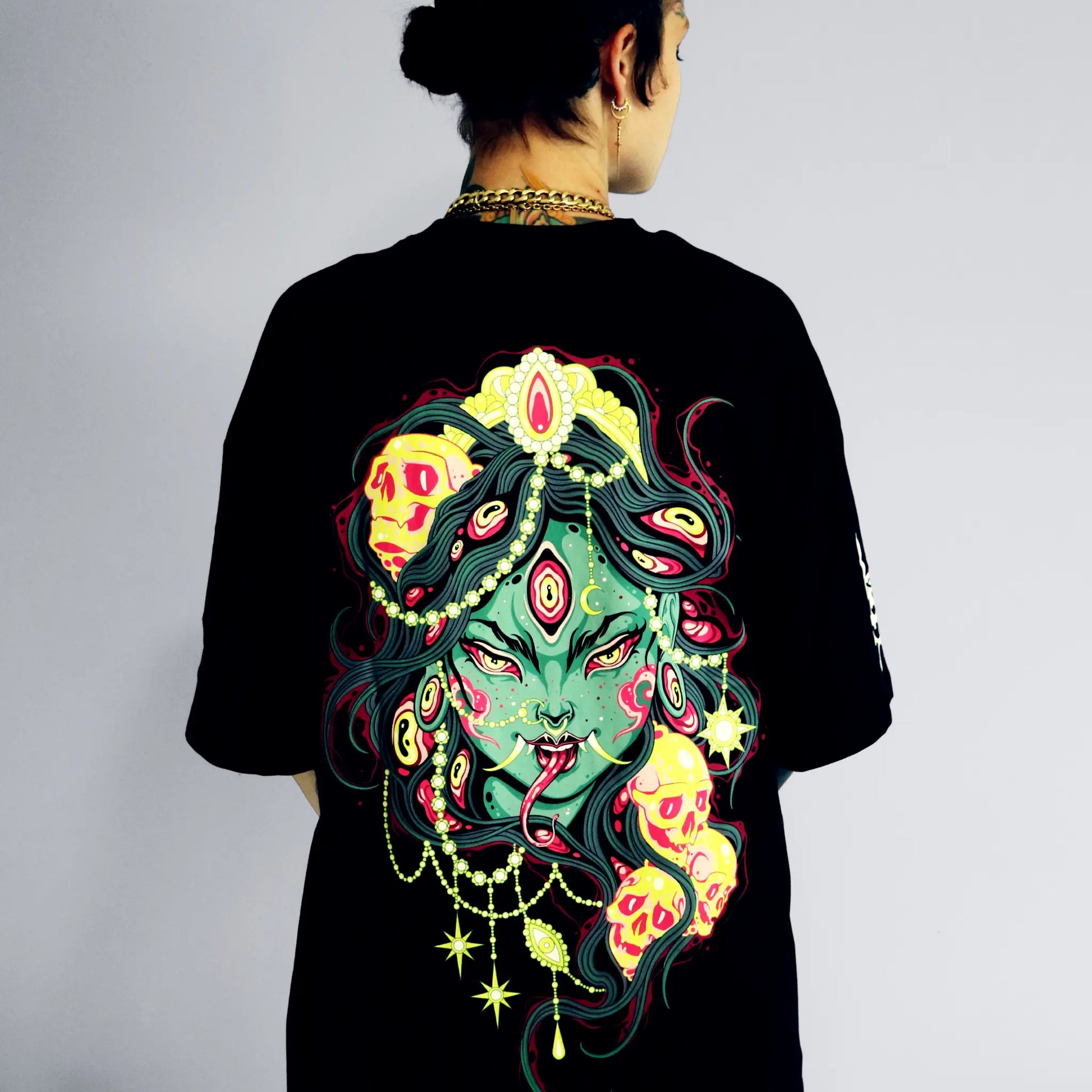 Person wearing a black t-shirt with a colorful and detailed design on the back.