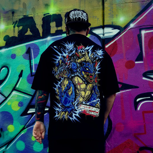 Person wearing a black t-shirt with a colorful graphic design, standing in front of a vibrant graffiti wall. RTLA-Apparel