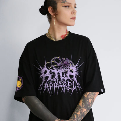 Person wearing a black oversized t-shirt with a graphic design on a plain background