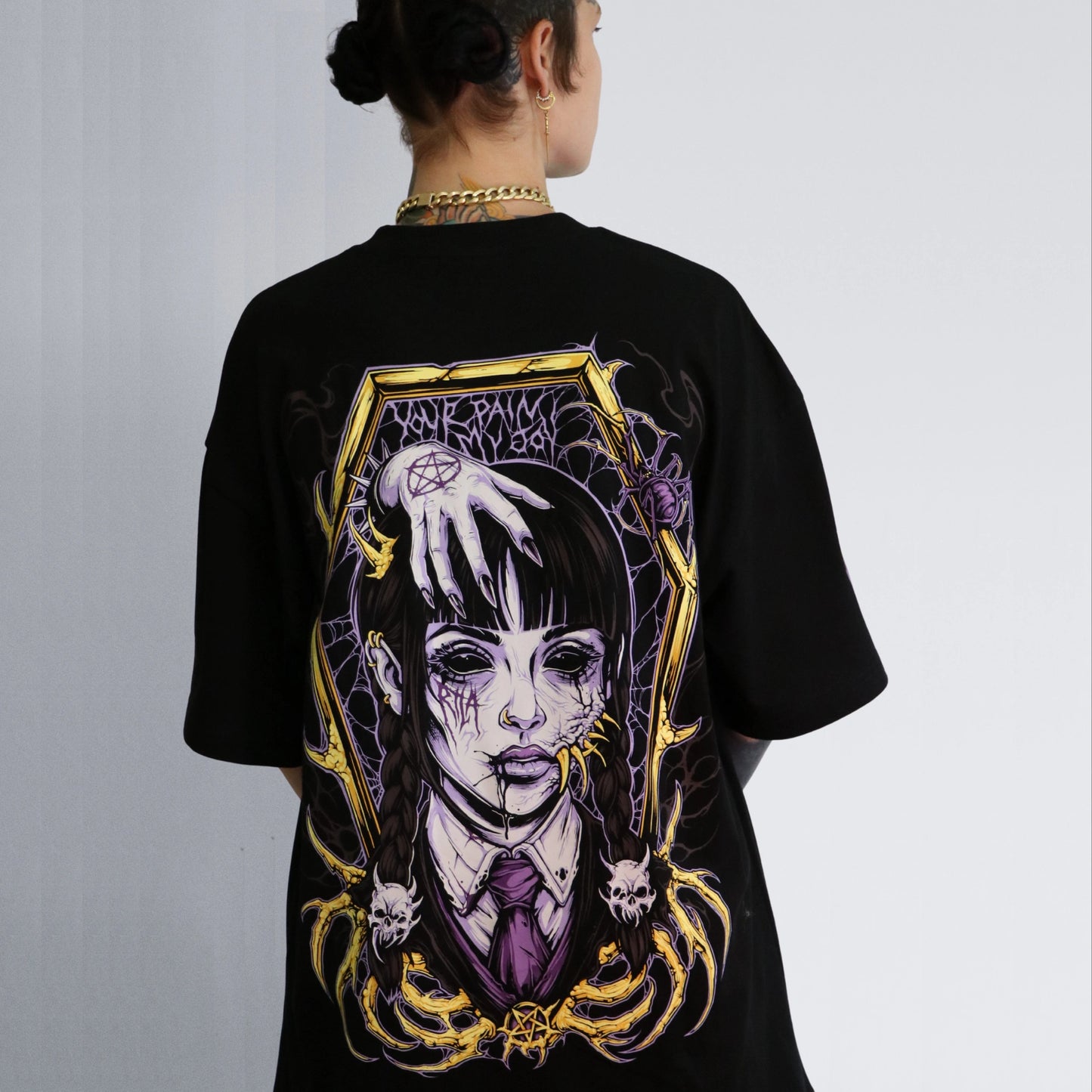 Black t-shirt with a graphic design on the back, featuring a stylized face and decorative elements.