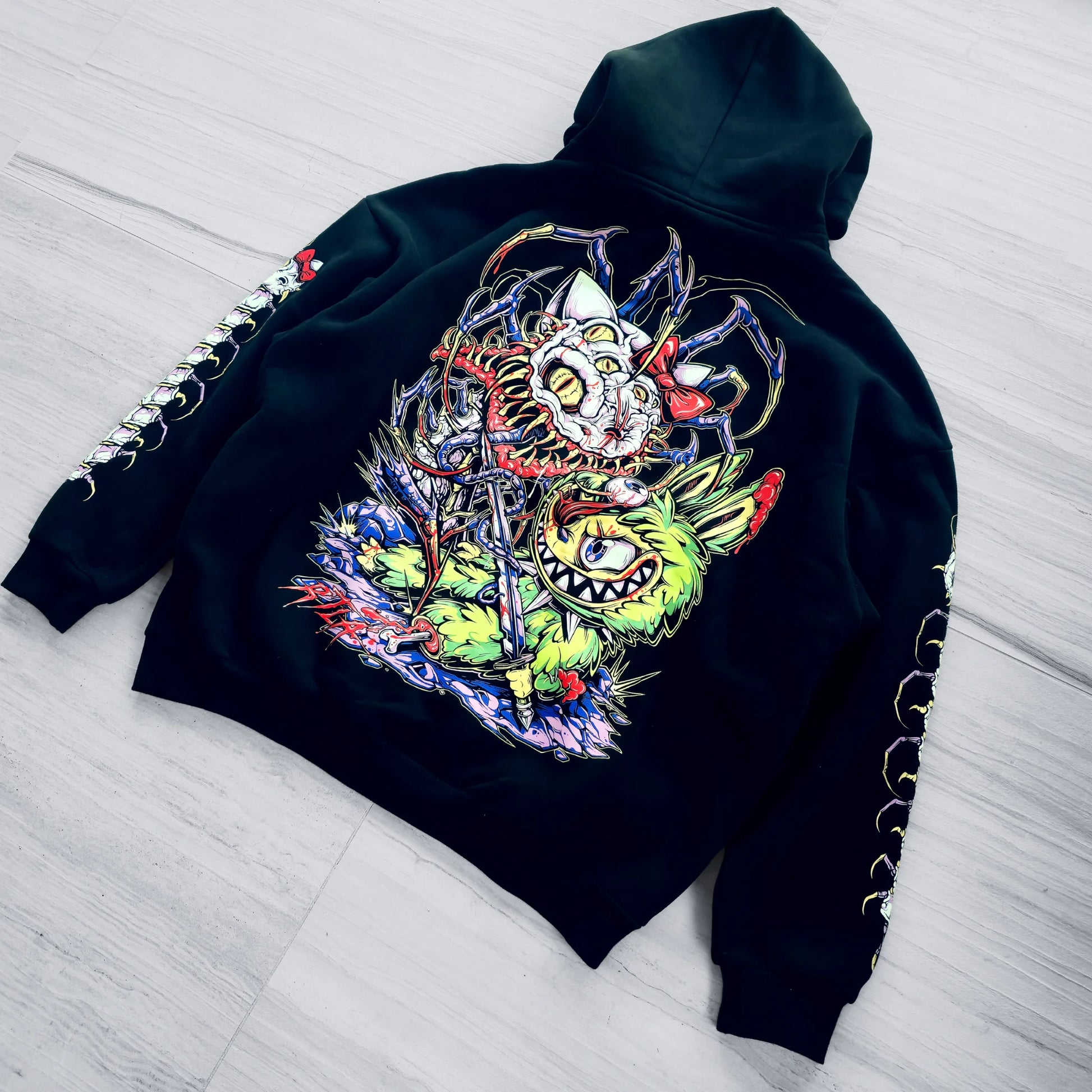 Black hoodie with colorful graphic design on a light wooden floor