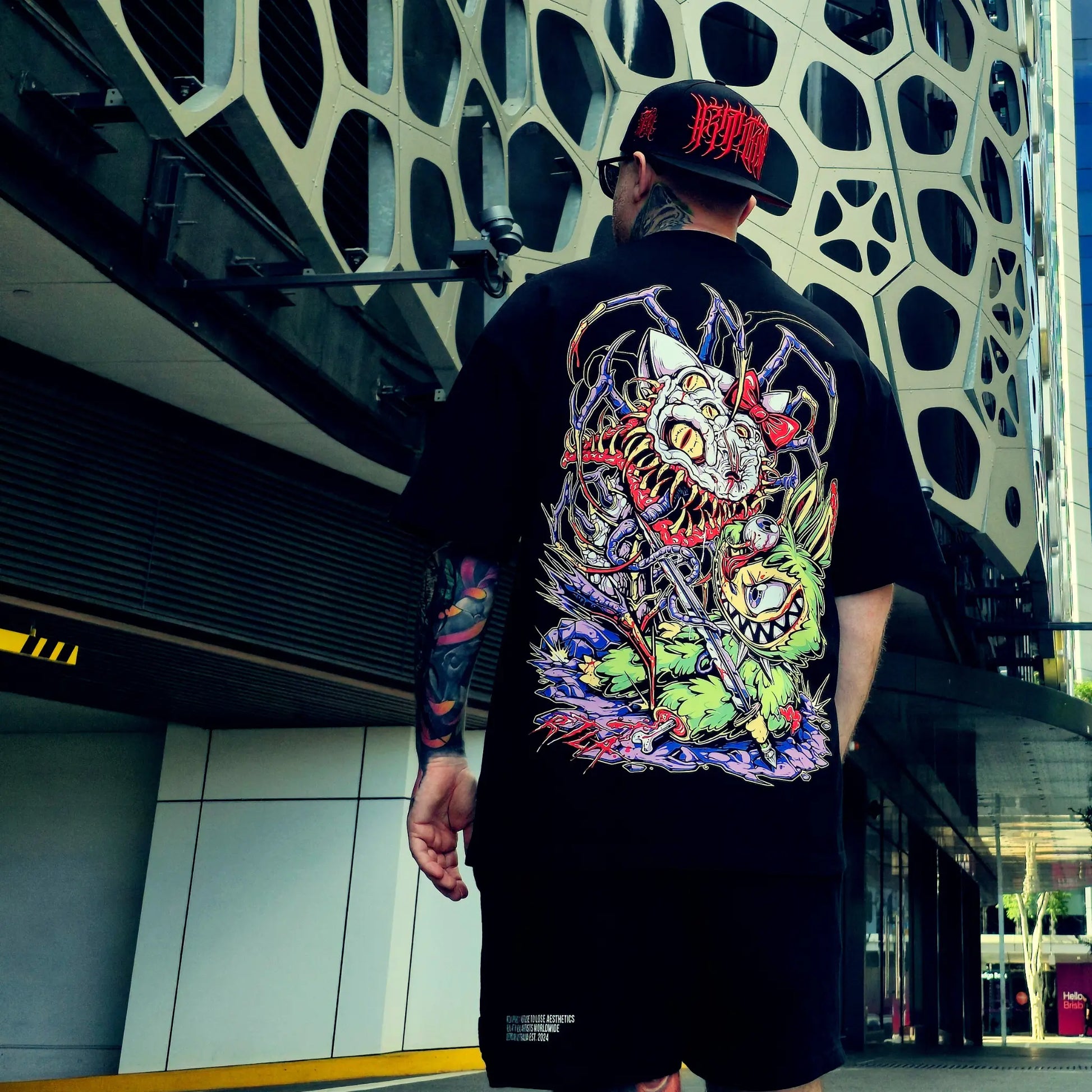 Person wearing a black t-shirt with a colorful dragon design outdoors.