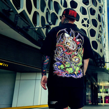 Person wearing a black t-shirt with a colorful dragon design outdoors.