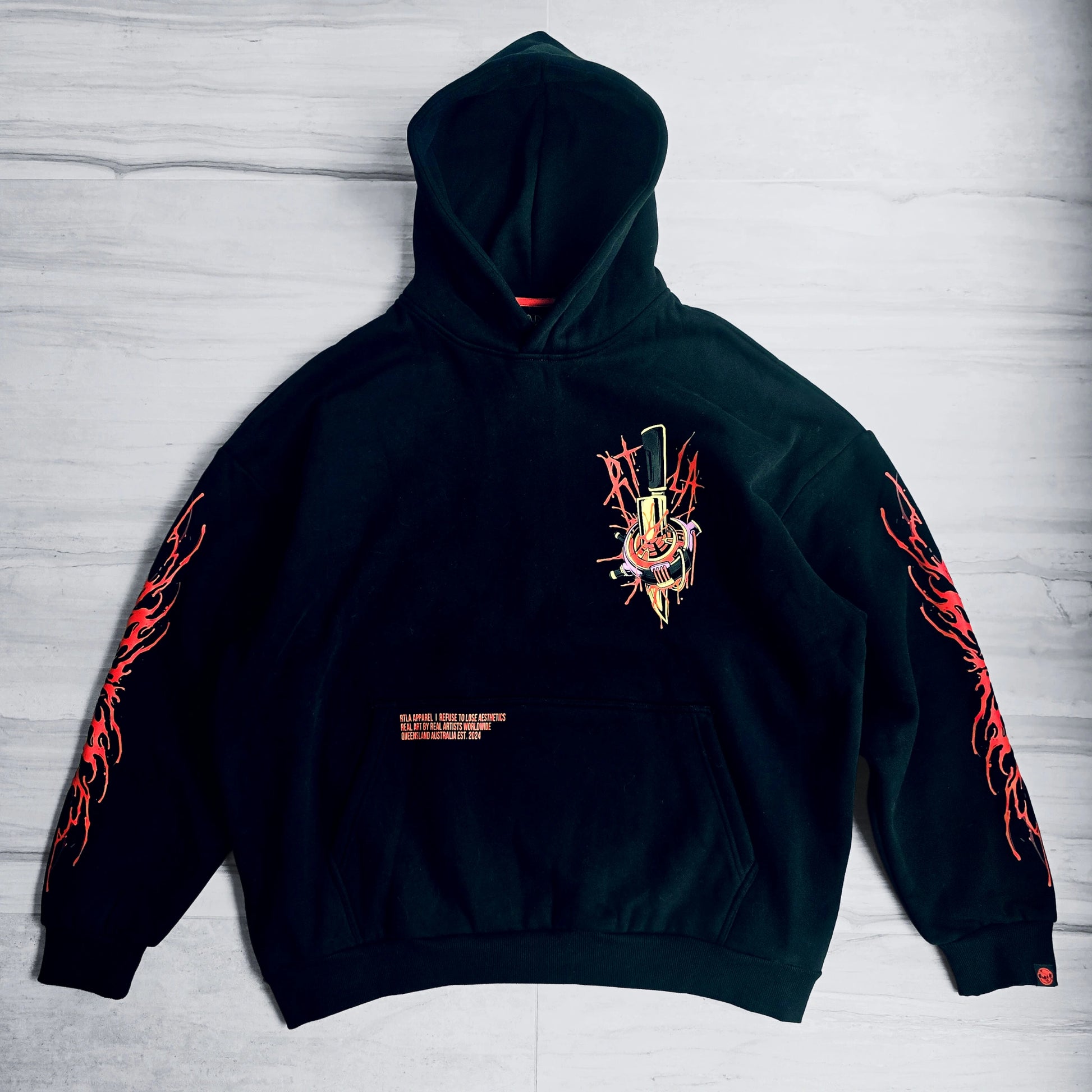 Black hoodie with red and orange designs on a light gray background