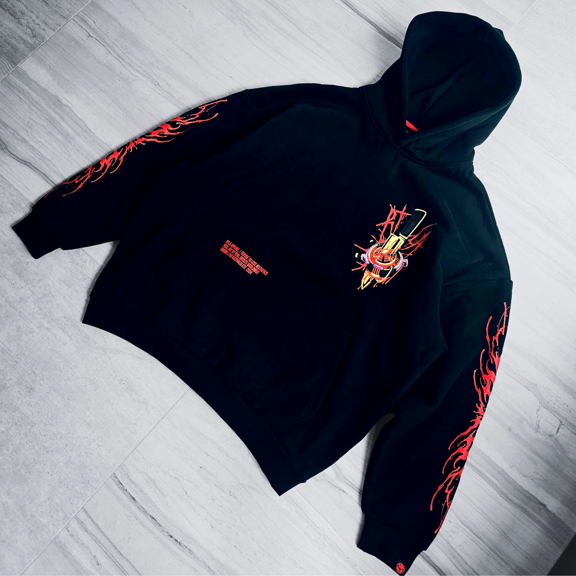 Black hoodie with red and yellow designs on a light gray floor