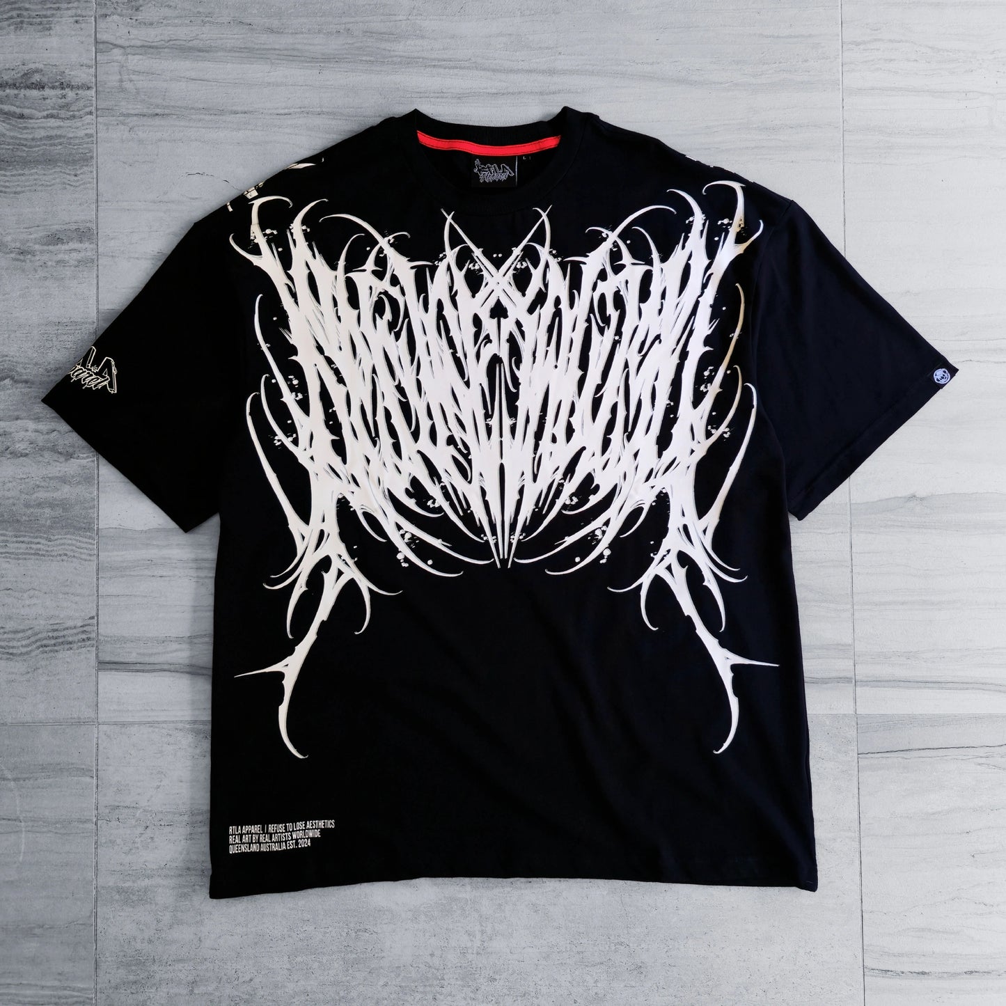 Black t-shirt with white abstract design on a gray wooden surface