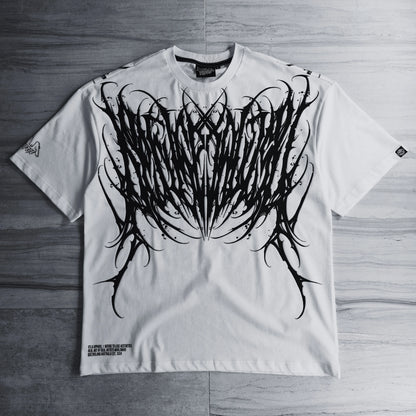 White t-shirt with black tribal design on a wooden surface