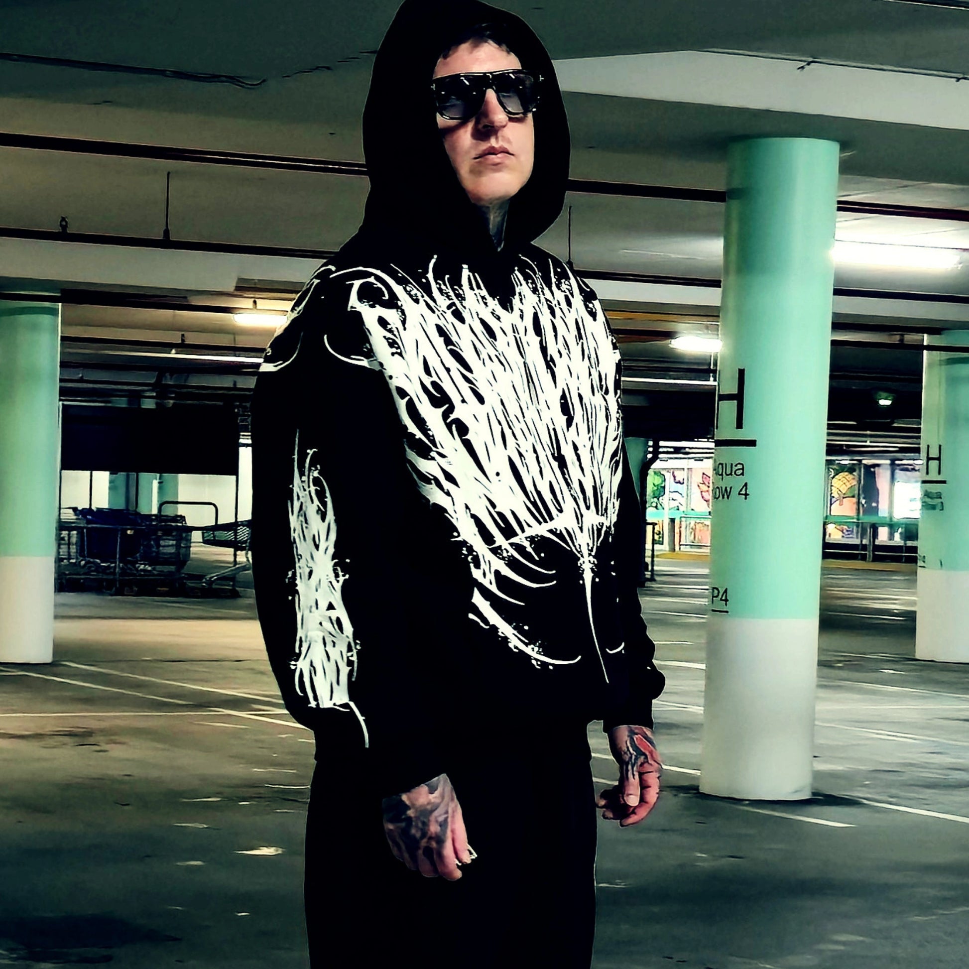 Person wearing a black hoodie with white design in front and back