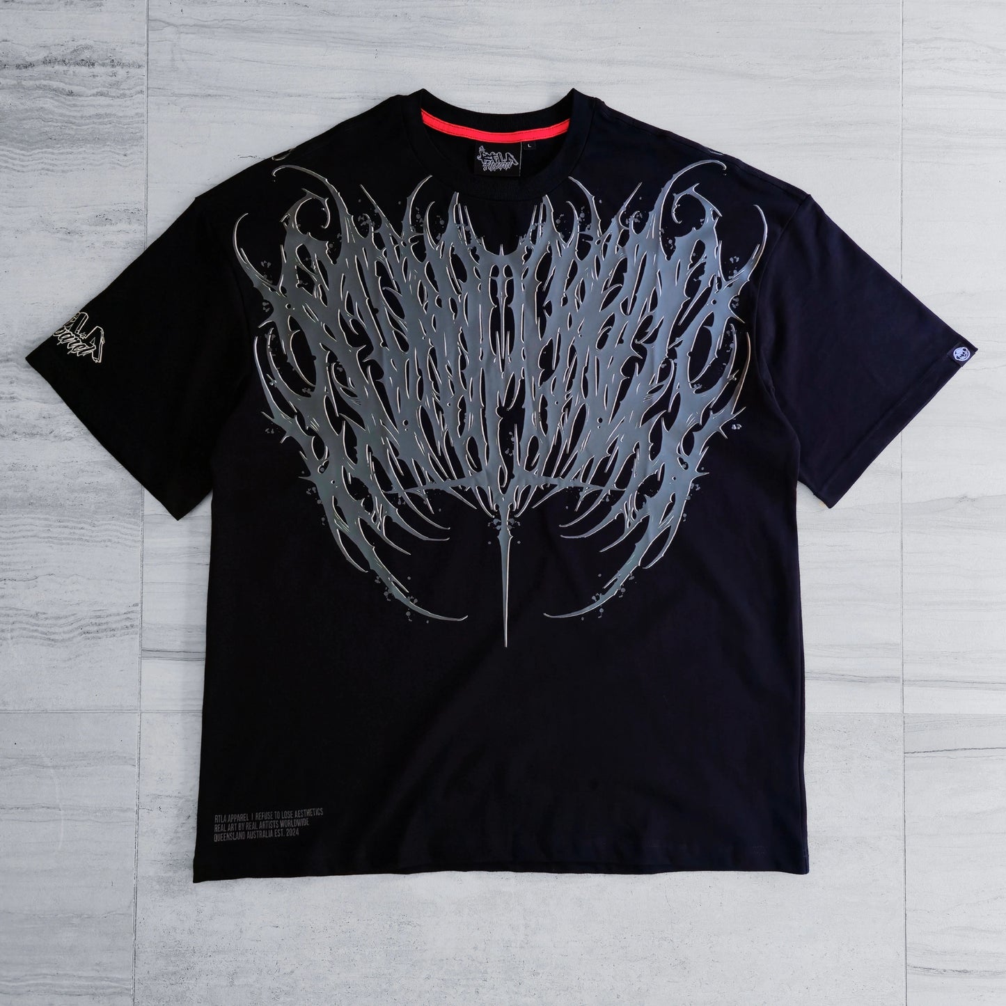 Black t-shirt with a large white graphic design on a gray wooden surface