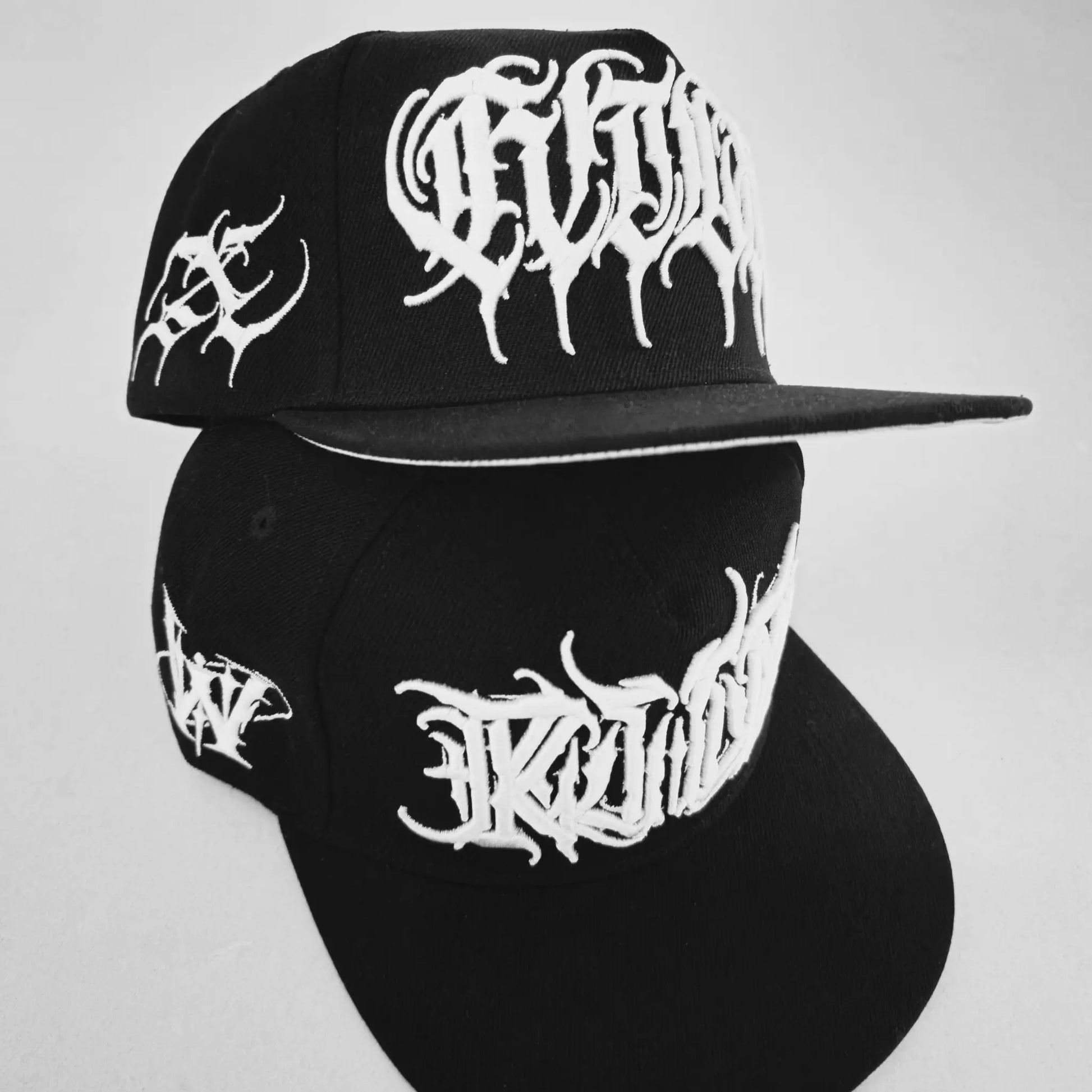 Black cap with white logo on a gray background. RTLA-Apparel