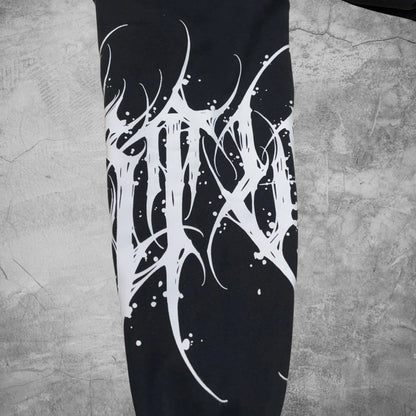 Black leggings with white abstract design on a textured gray surface