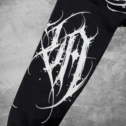 Black pants with white abstract design on a textured gray background