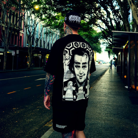 Person wearing a black t-shirt with graphic designs on a city street