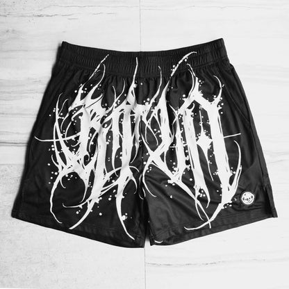Black shorts with white abstract design on a light wooden floor