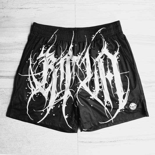Black shorts with white abstract design on a light wooden floor
