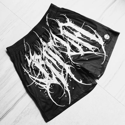 Black shorts with white abstract design on a light wooden floor