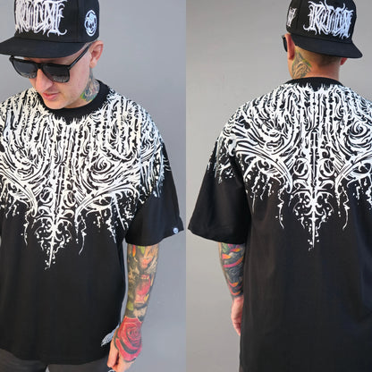 A person wearing a black oversized t-shirt with a white text and script work design, mirrored on both front and back.  RTLA Apparel