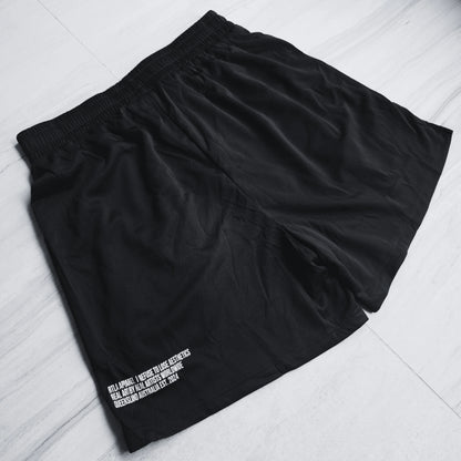 Black shorts with white text on a light gray surface