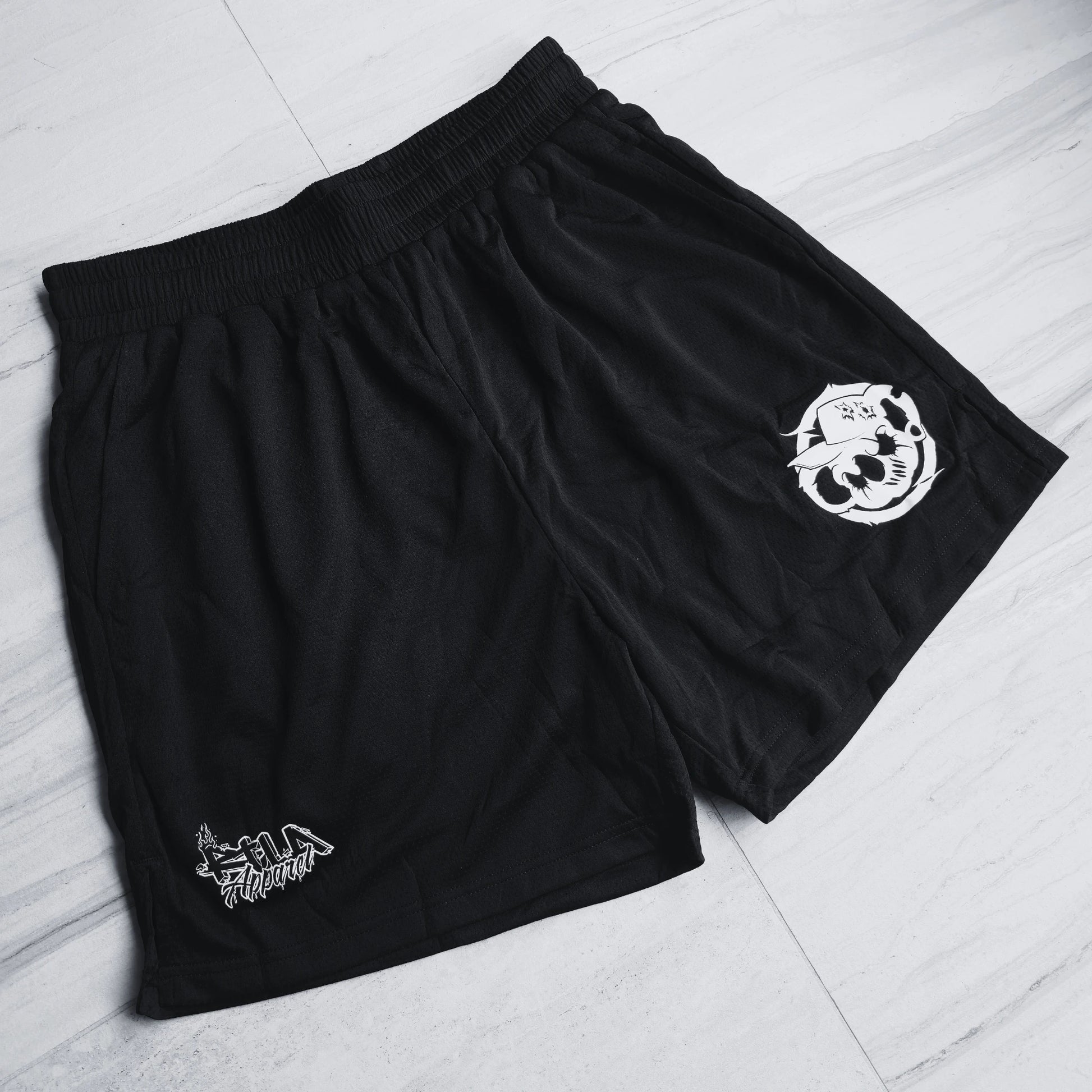 Black shorts with white logos on a light gray floor