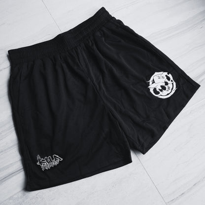 Black shorts with white logos on a light gray floor