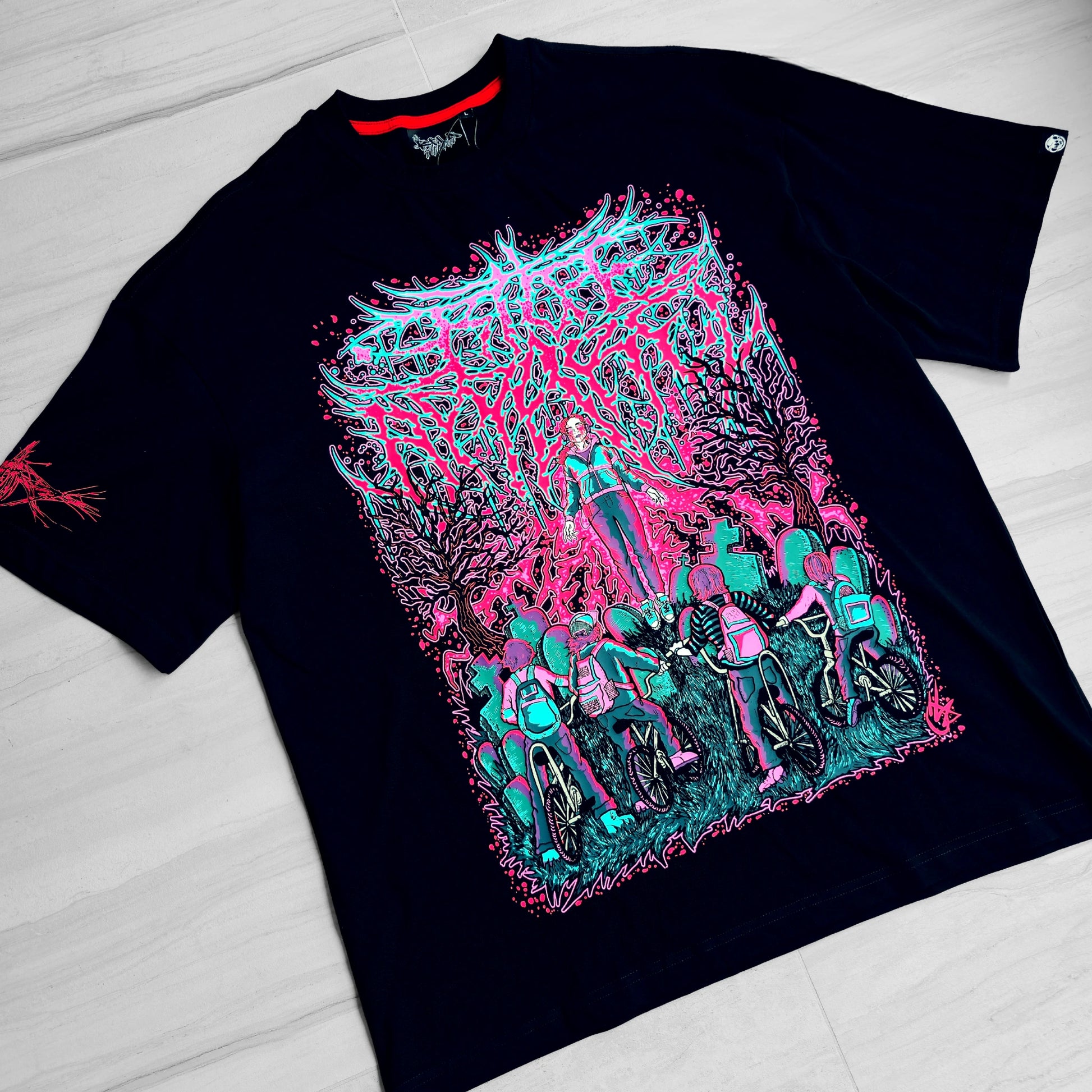 Black t-shirt with colorful graphic design on a light wooden surface