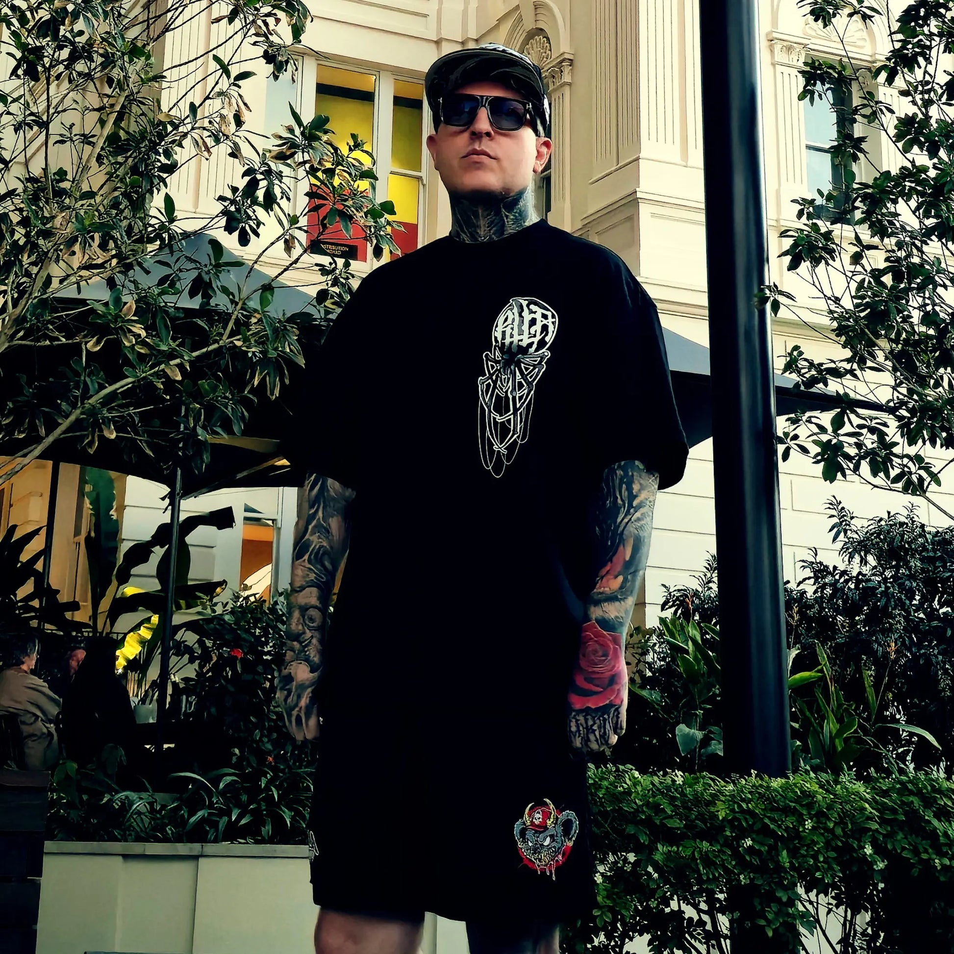 Man wearing a black t-shirt with a graphic design in an urban setting