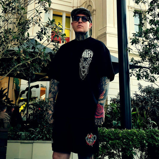 Man wearing a black t-shirt with a graphic design in an urban setting