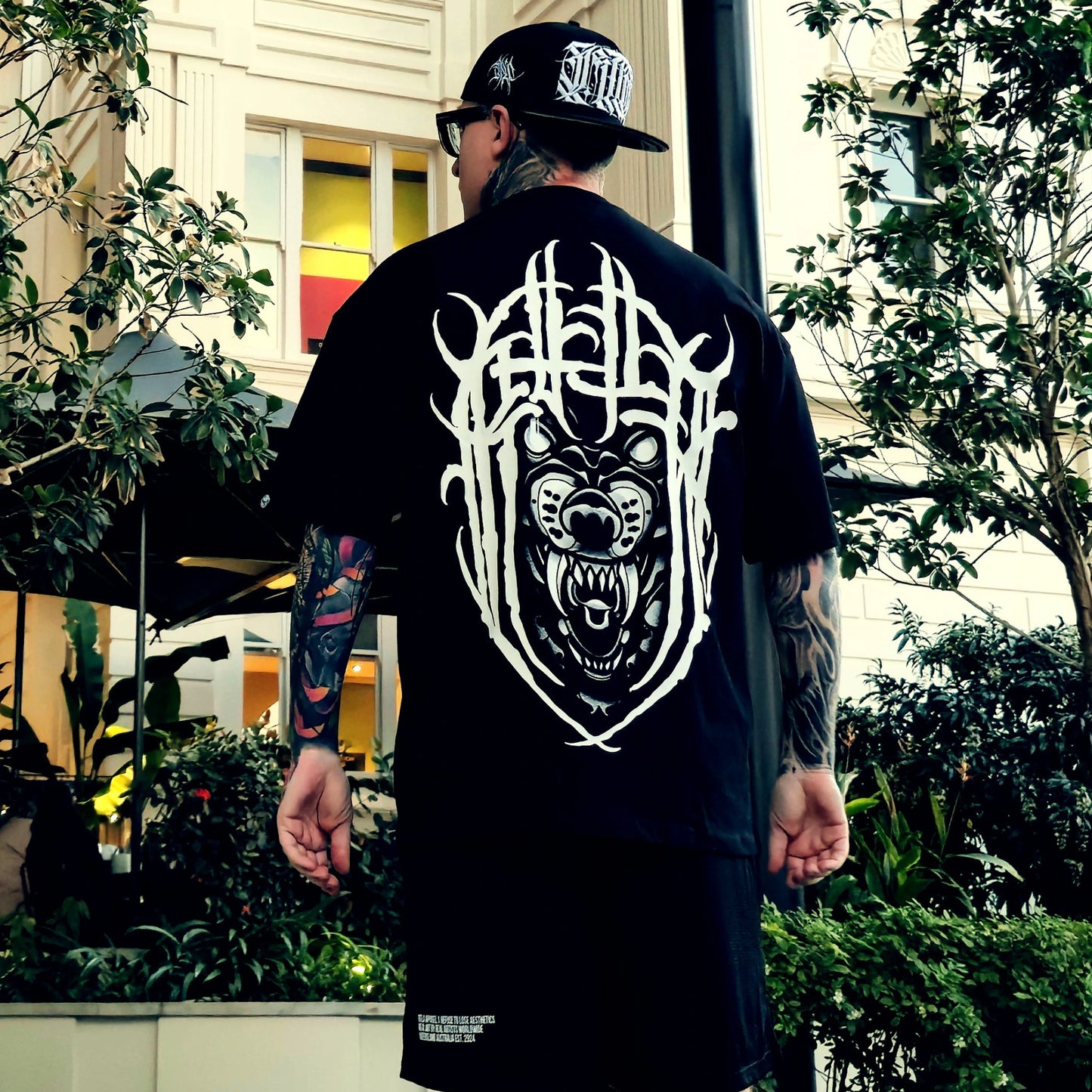 Person wearing a black t-shirt with a white graphic design outdoors