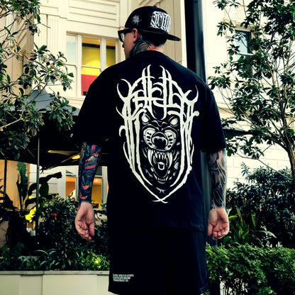 Person wearing a black t-shirt with a white graphic design outdoors