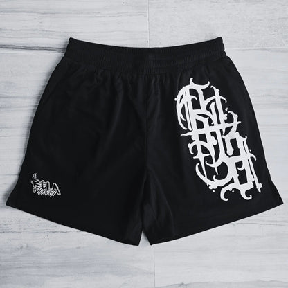 Black shorts with white graphic design on a light wooden floor