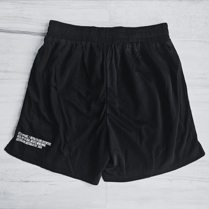 Black shorts with text on a light gray surface