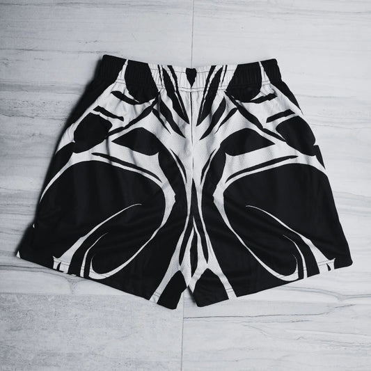 Black and white patterned shorts on a light wooden floor